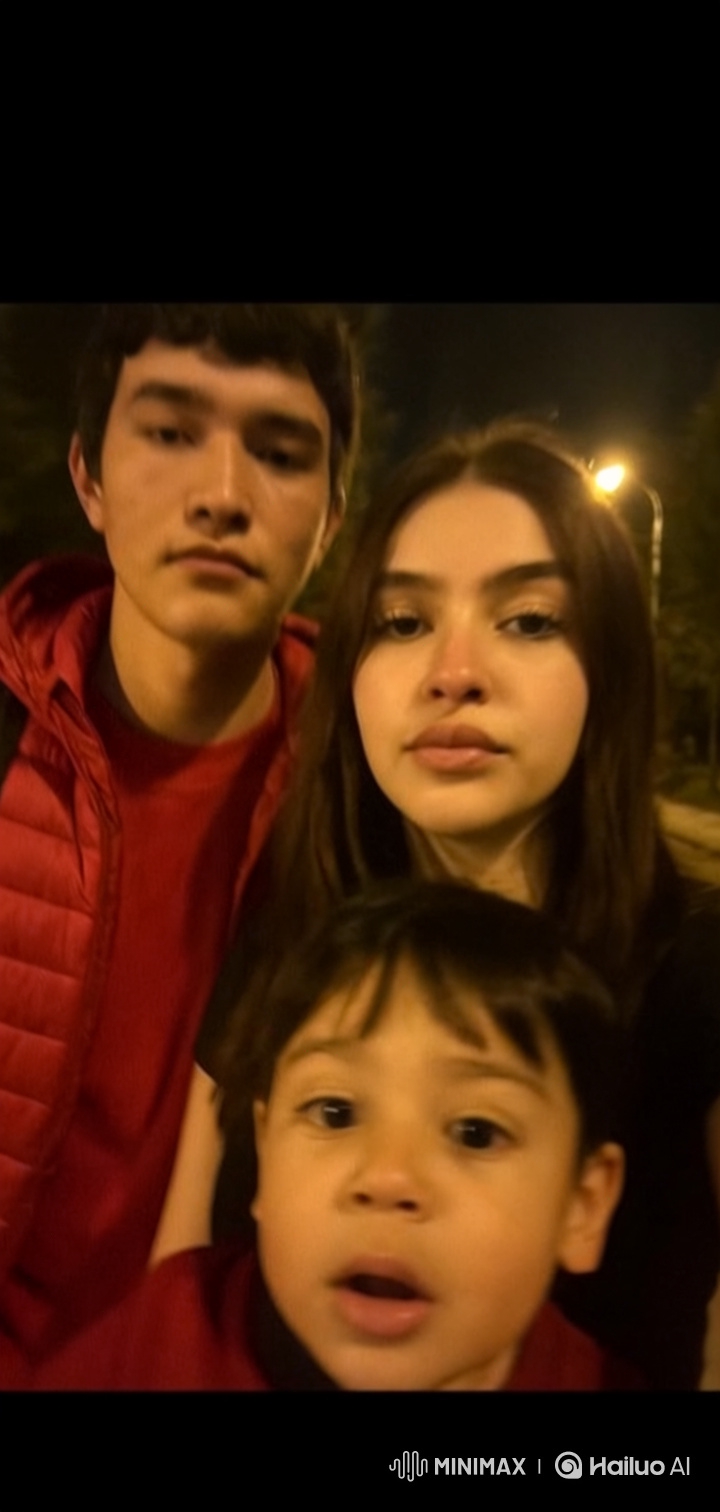 Young Couple and Daughter Embrace Under Streetlights