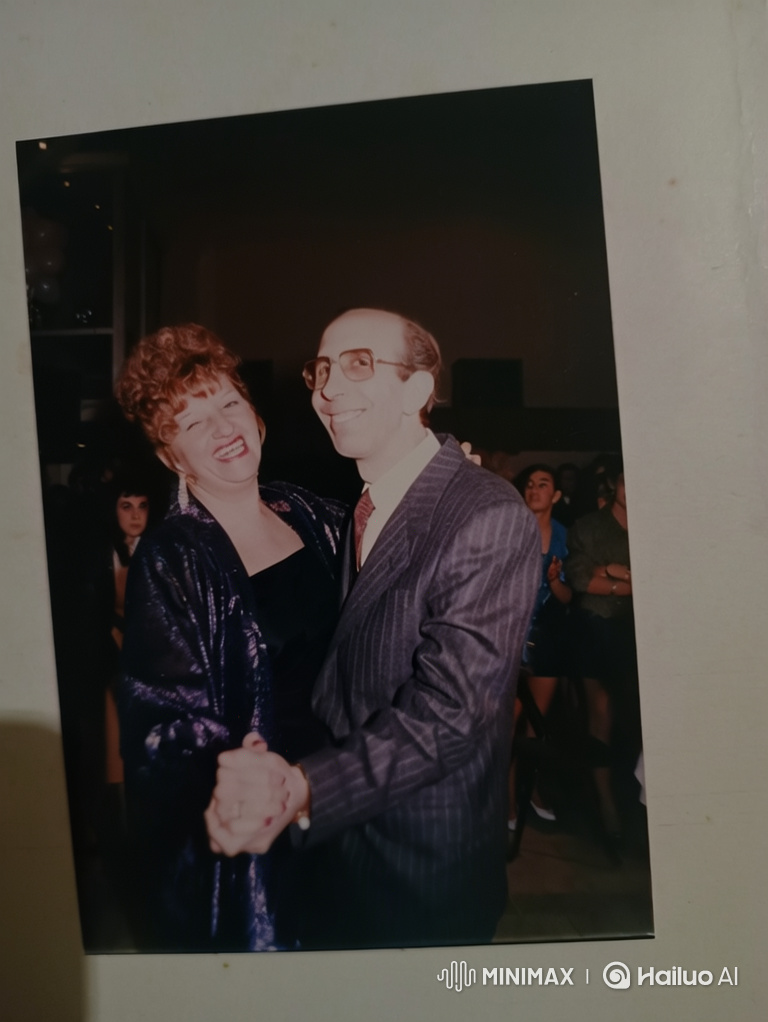 Couple's Intimate Dance and Embrace at a Lively Party