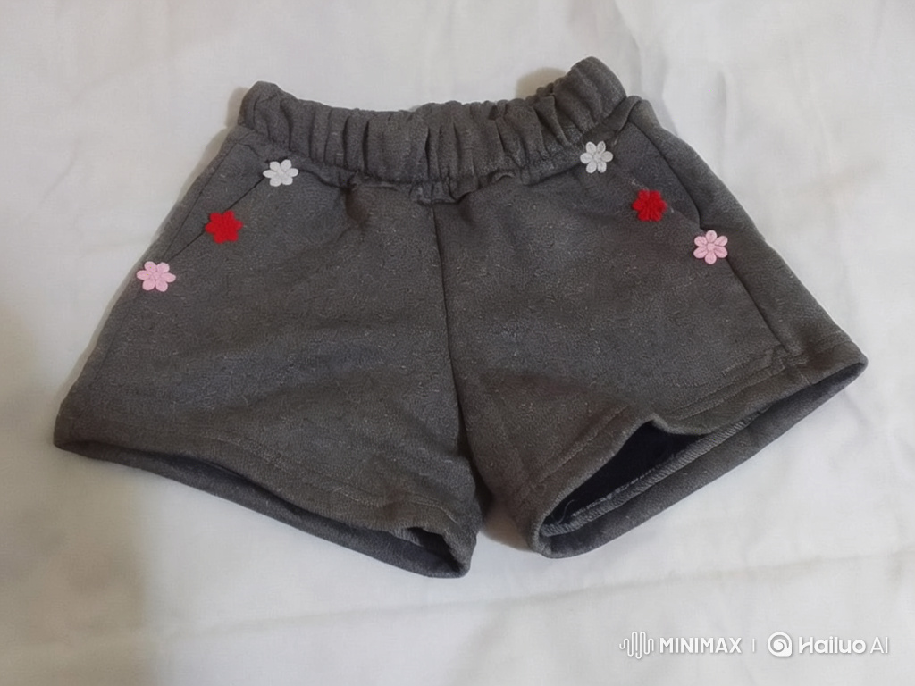 Woman Gives Shorts to Joyful Little Girl in Cozy Living Room